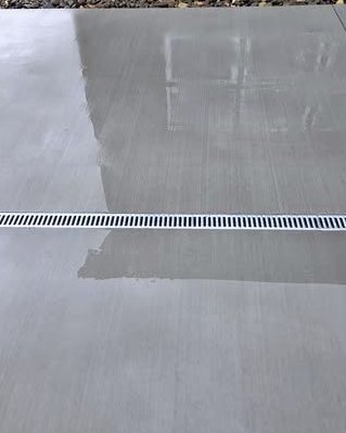 Smooth gray concrete slab with a linear trench drain in Kannapolis, NC