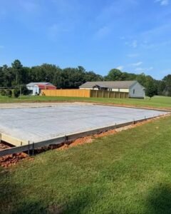 Concrete slab with wire mesh and wood forms in a grassy yard in Kannapolis, NC